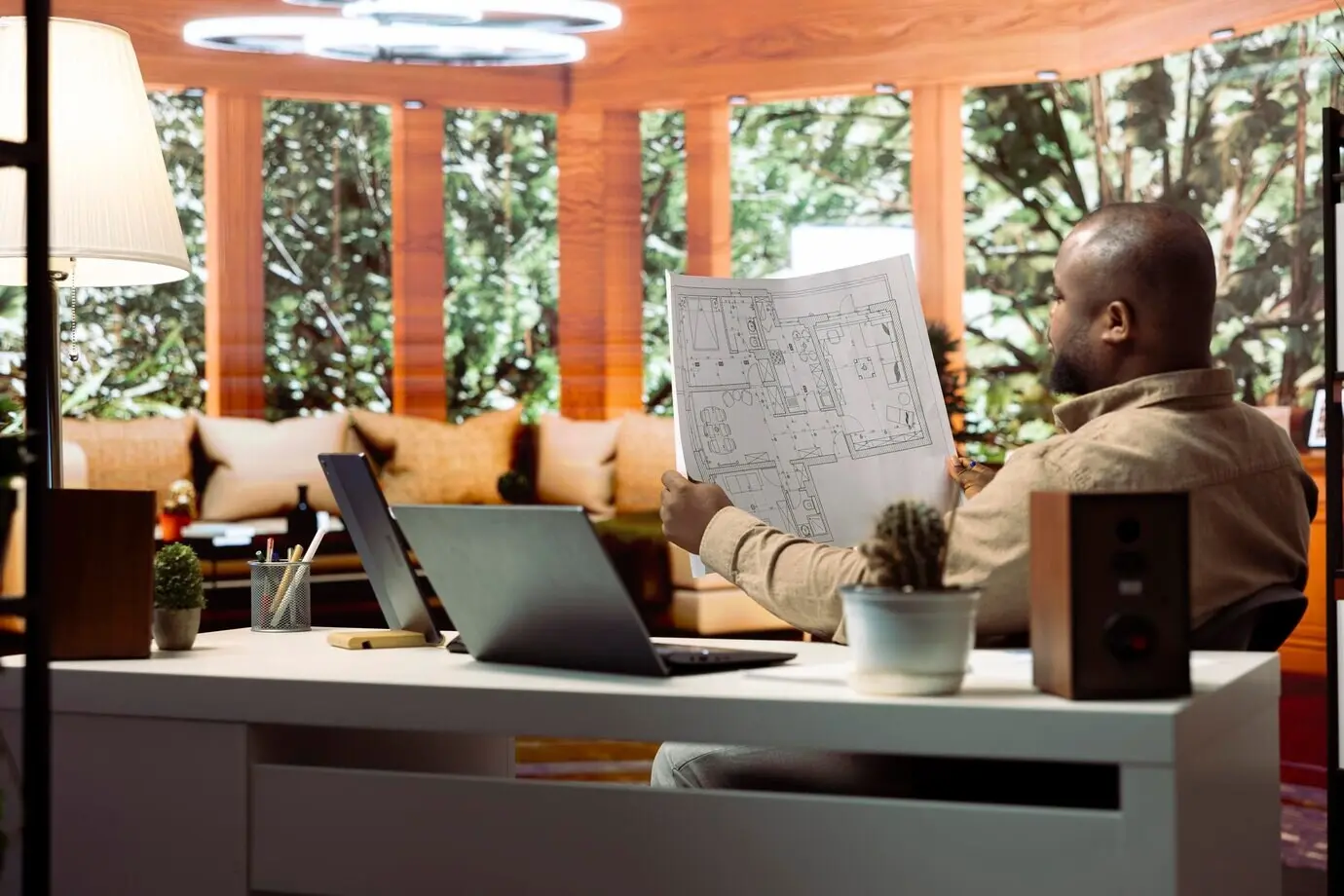 Emprendedor trazando planos arquitectónicos y planificando un traslado de oficina.